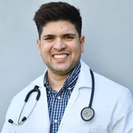 Male doctor smiling, wearing a white coat and stethoscope.