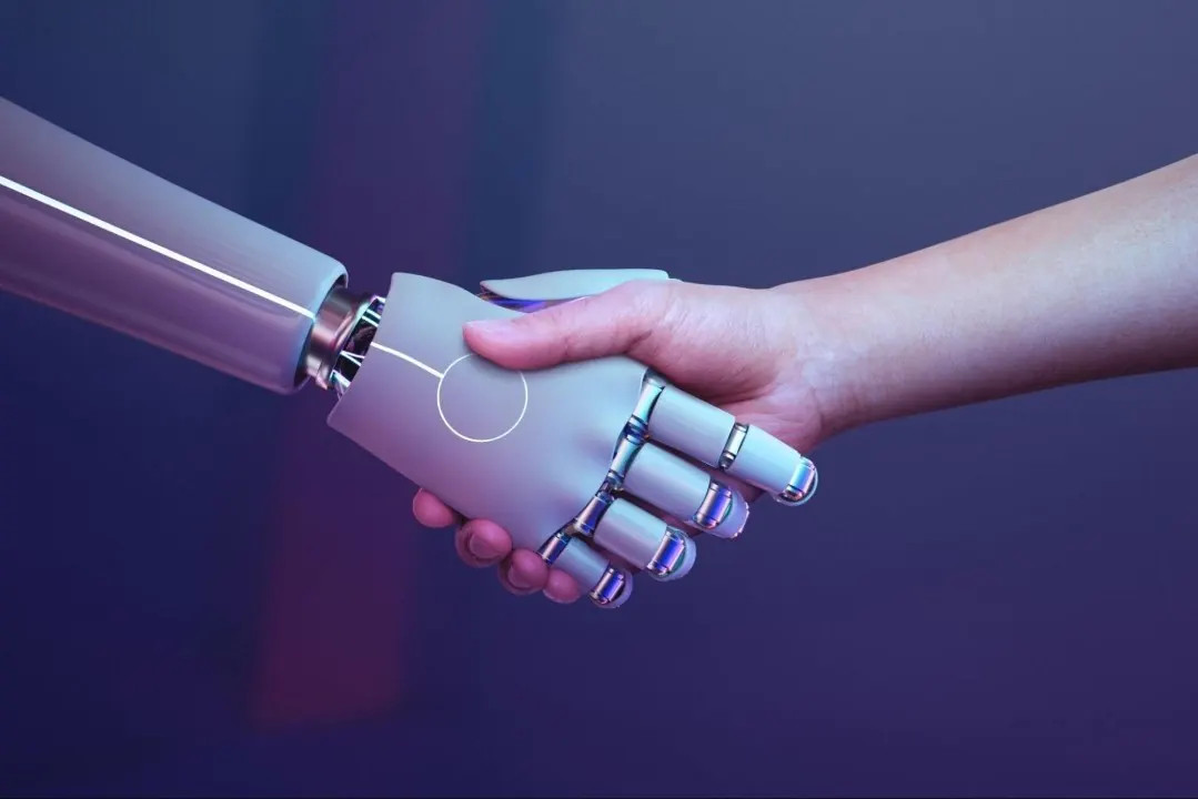 Human hand shaking robot hand on blue background